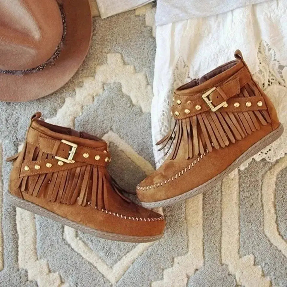Earthy Tones set the tone for effortless style in these studded fringe suede flat boots by Grace Step. Designed to feel like a second skin, the vegan suede contours gently to your foot, creating a balanced mix of grounded elegance and playful charm. Whether dressing up denim or offsetting a neutral maxi dress, this boot adds instant personality to any look.