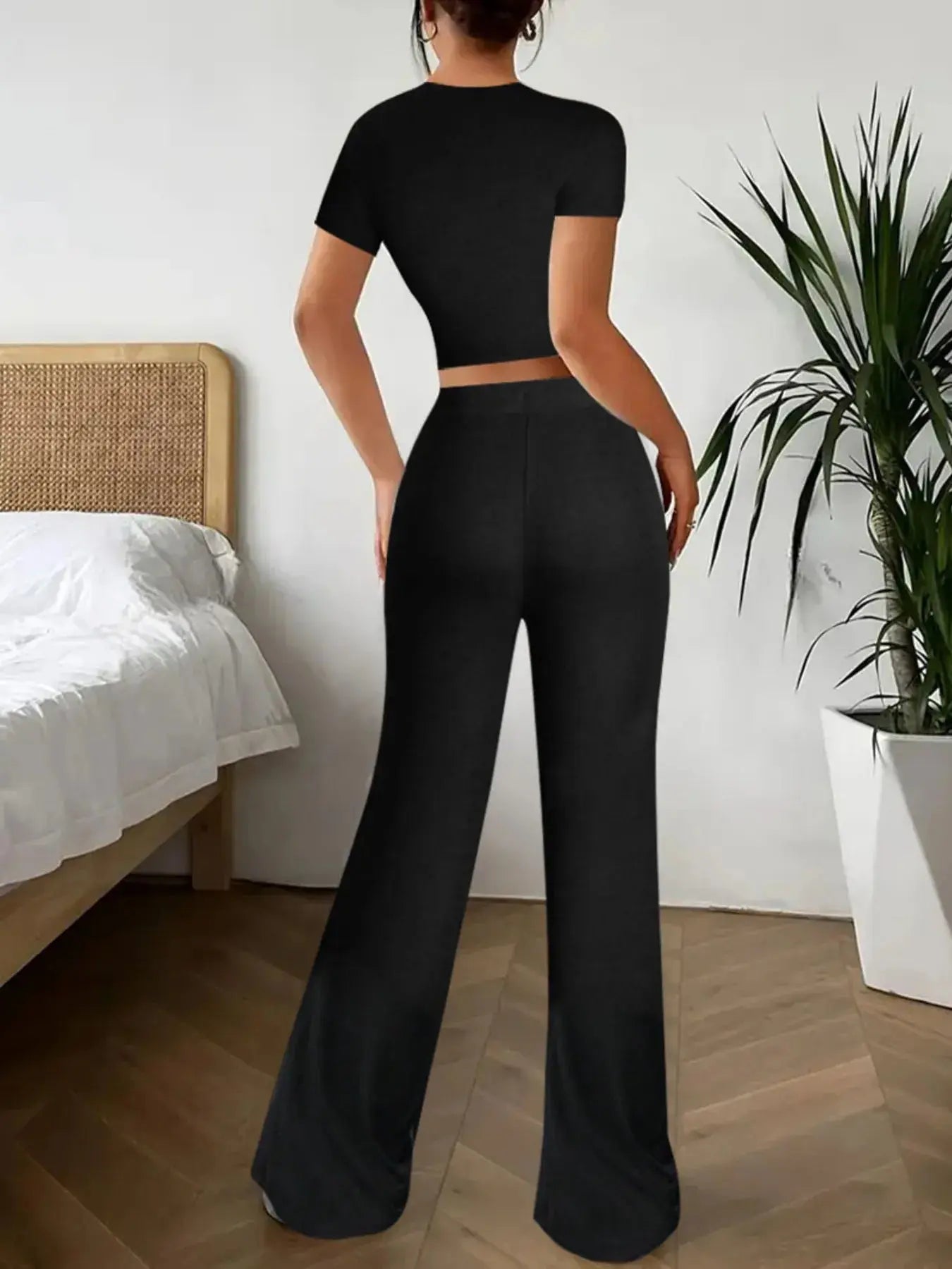 Elevate your off-duty wardrobe with this sleek black two-piece set, featuring a fitted crop top and high-waisted wide-leg pants. The top hugs your frame with a flattering silhouette, while the flowy pants offer all-day comfort and movement. Whether you're lounging at home or heading out for errands, this ensemble delivers polished ease with minimal effort.