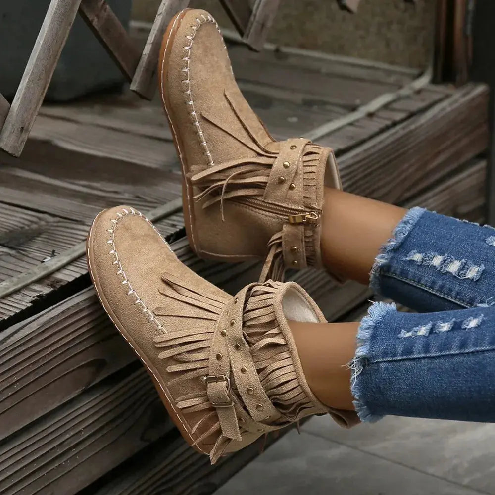 Earthy Tones set the tone for effortless style in these studded fringe suede flat boots by Grace Step. Designed to feel like a second skin, the vegan suede contours gently to your foot, creating a balanced mix of grounded elegance and playful charm. Whether dressing up denim or offsetting a neutral maxi dress, this boot adds instant personality to any look.