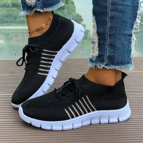Model wearing a black pair of the Breathable Mesh Round Toe Sneakers.
