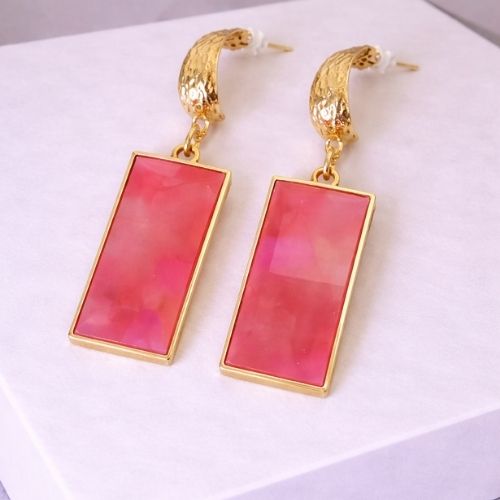 Gold earrings with pink rectangular stones on a white background