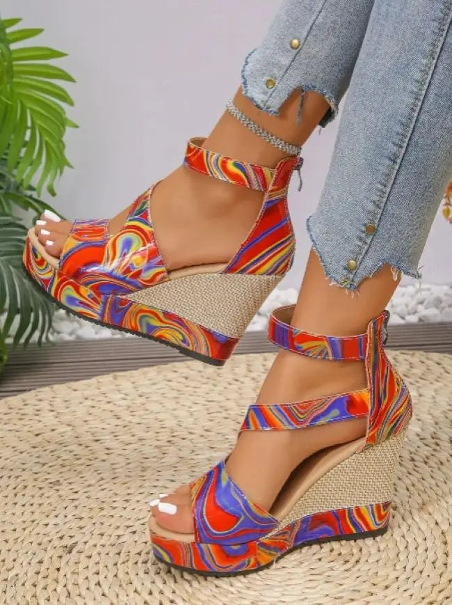 Colorful platform sandals worn with light denim jeans on a woven surface.