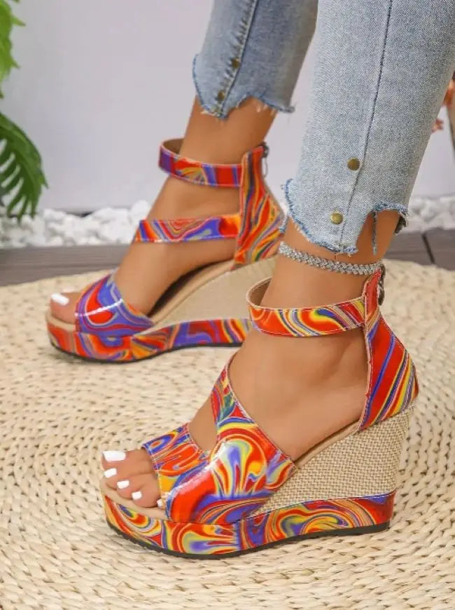 Colorful platform sandals worn with light blue jeans on a woven surface.