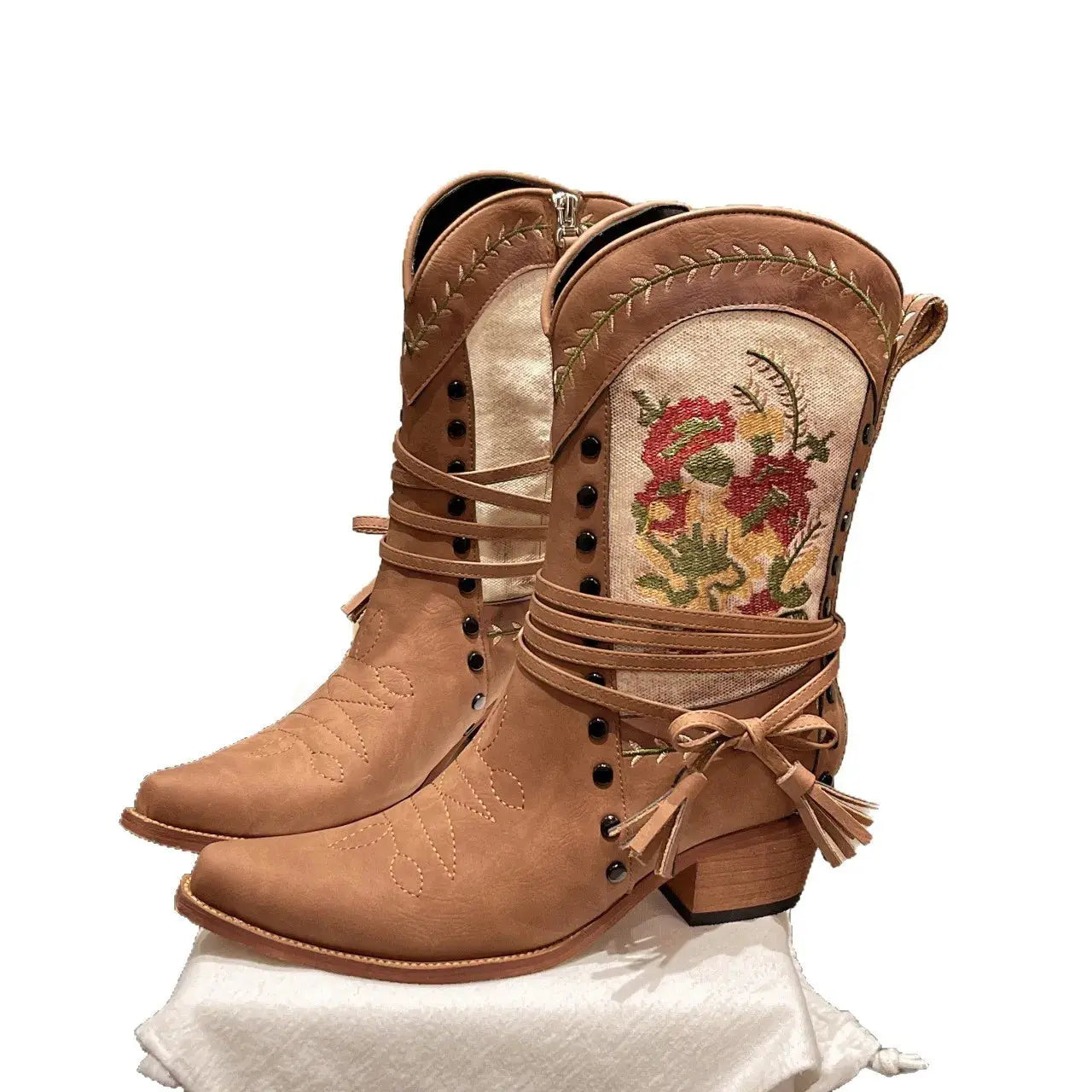 Tan cowboy boots with floral embroidery on a white background.