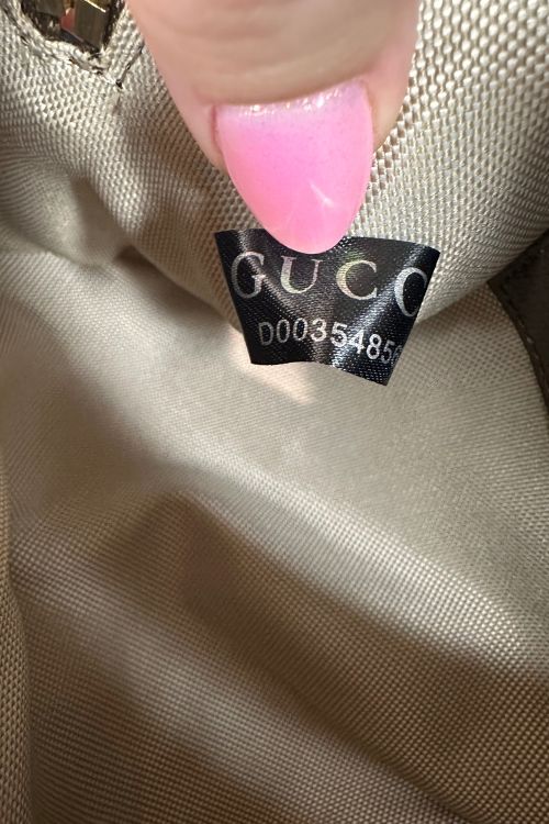 Close-up of a Gucci label on a beige fabric background