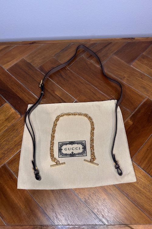 Gucci handbag on a beige cushion with Gucci logo on a wooden floor