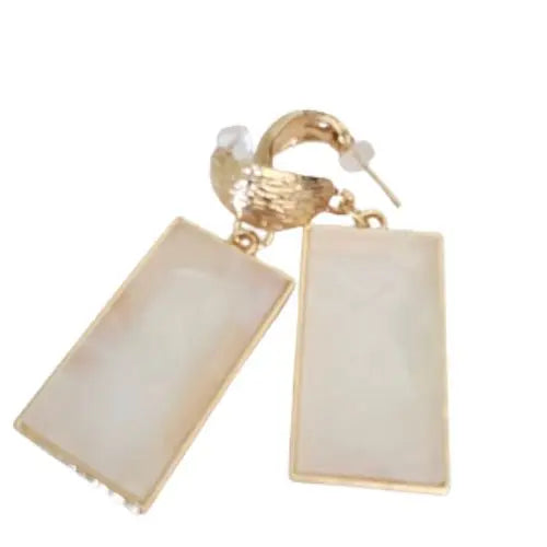 Gold and pearl-toned resin earrings catching light with soft shimmer — elevated statement jewelry by Atlas by J&D