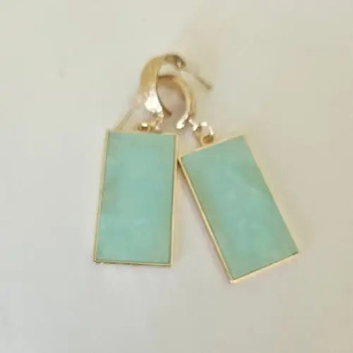 Gold hoop earrings featuring glossy soft green resin pendants with soft shimmer — women’s boutique jewelry by Atlas by J&D.