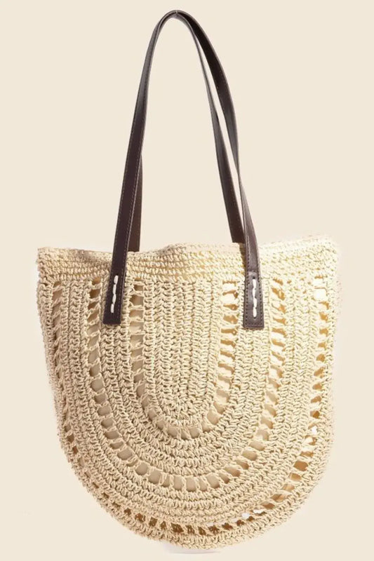 Beige woven handbag with black handle on a beige background.