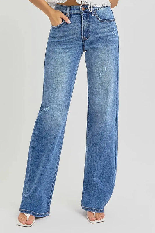 Relaxed fit blue jeans worn by a person on a light gray background