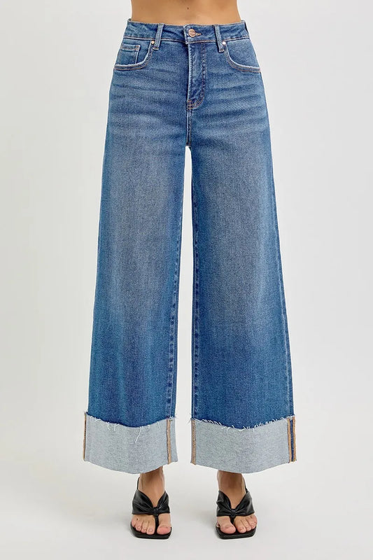 Wide-leg ankle length cuffed blue jeans on a white background