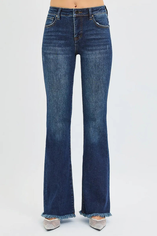 Dark washed blue jeans with frayed hems on a white background
