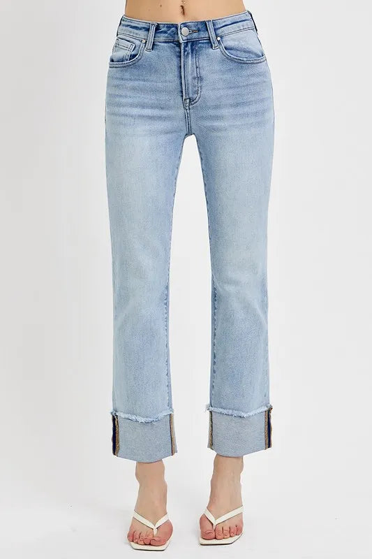 Light wash blue jeans with a large cuff on a white background