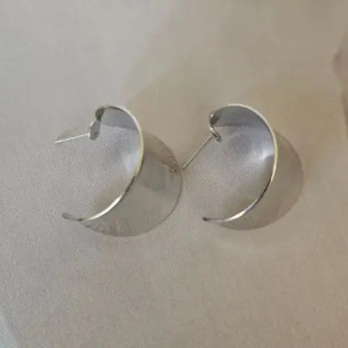 Polished silver cuff earrings with sculptural curved shape — Atlas by J&D women’s boutique jewelry.