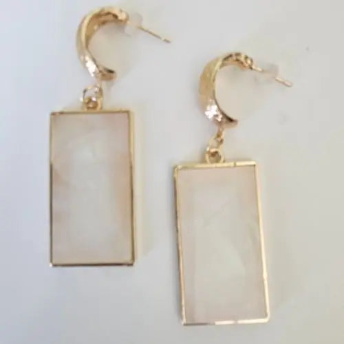 Close-up of gold hoop earrings with rectangular opal-inspired pendants and glossy finish — women’s boutique jewelry from Atlas by J&D.