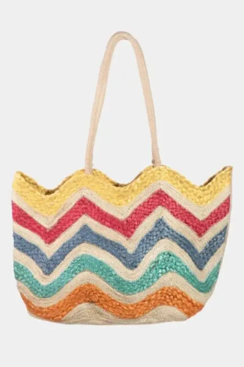 Colorful zigzag patterned woven hand bag on a white background.