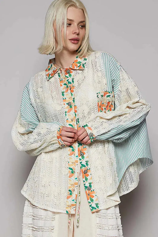 Person wearing a floral, striped, and crocheted button down blouse on a neutral background.
