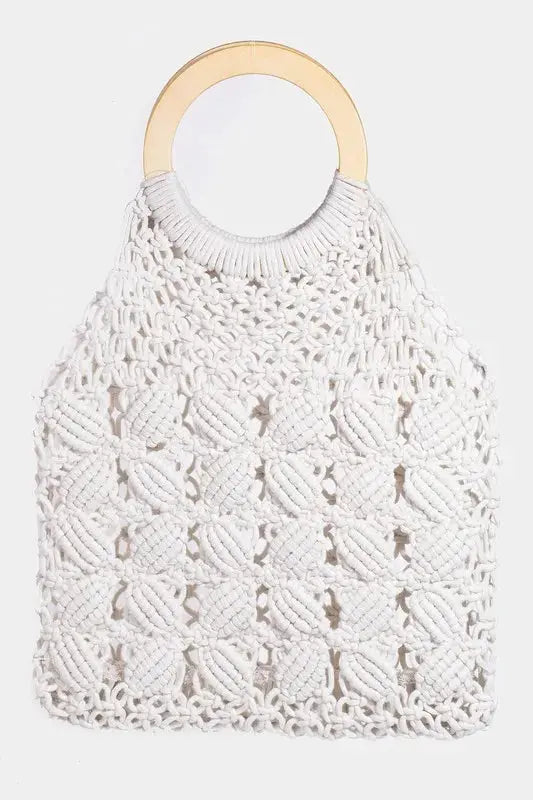 White macrame bag with wooden handle on a light gray background.