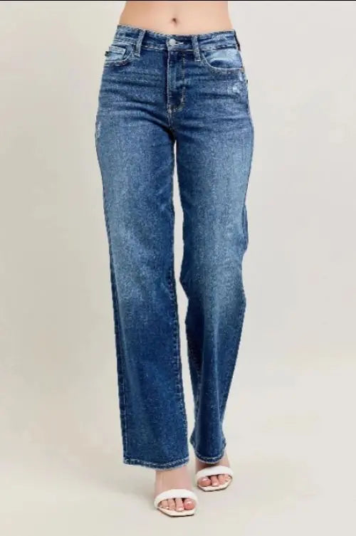 Blue jeans worn by a person on a plain background