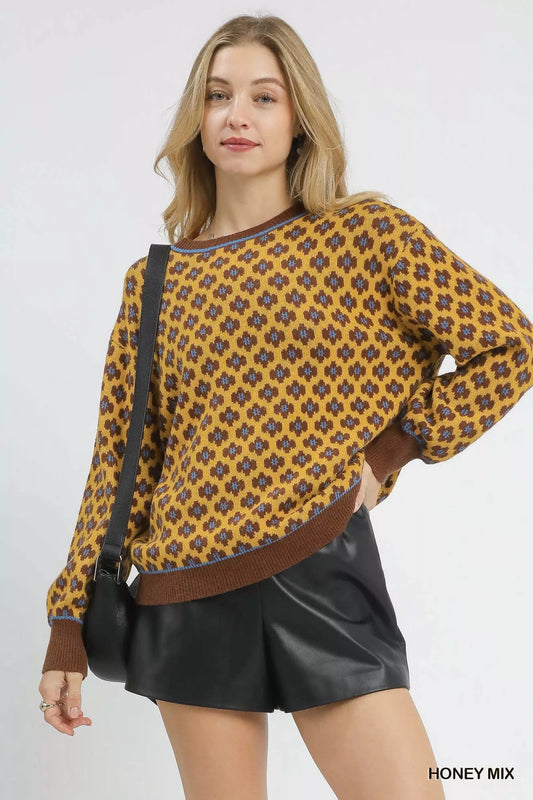 Woman wearing a patterned sweater with a brown bag and black shorts on a white background
