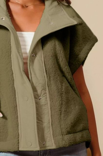 Olive green oversized sleeveless sherpa vest shown from a side angle highlighting wide collar and textured front panels.