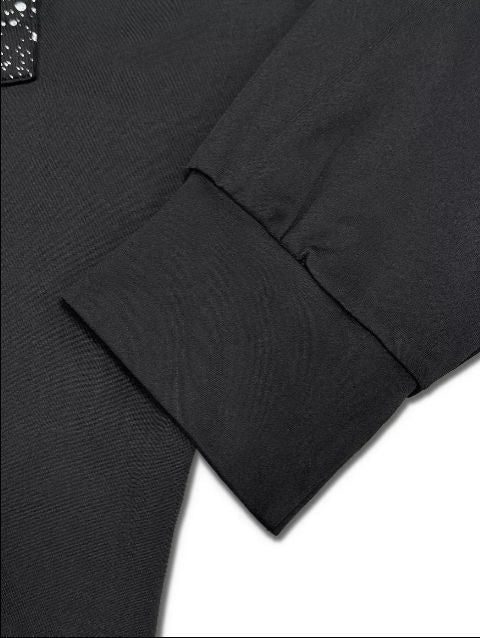 Close up detail of long sleeve cuff on a black top showing soft jersey fabric.