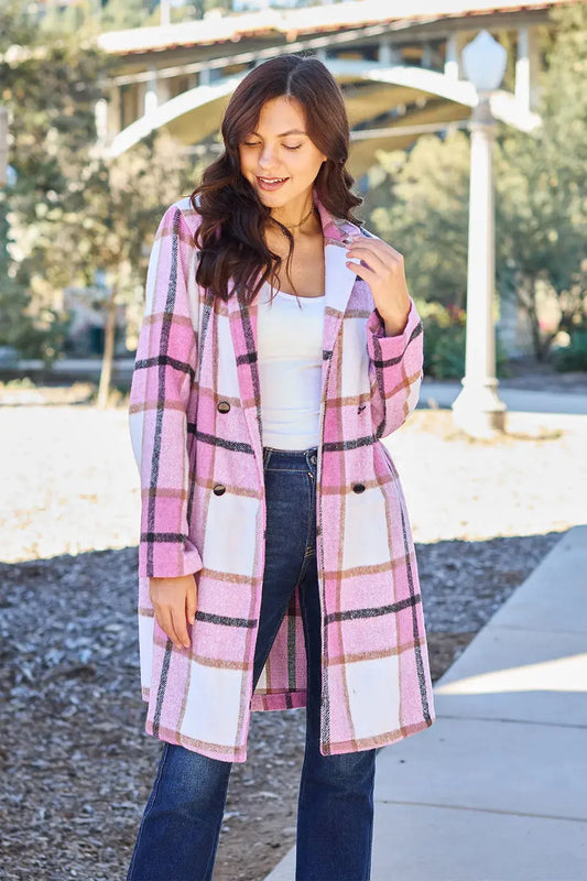 Wrap yourself in cozy charm with this Pink Plaid Button-Up Coat—a statement layer that blends warmth with playful sophistication. Designed in a soft checkered weave of blush, ivory, and brown, this midweight coat features a relaxed fit that’s perfect for layering over your everyday essentials. Classic button-front detailing and side pockets offer practicality, while the longline silhouette adds a modern, polished finish. Whether you're strolling downtown or escaping to a weekend cabin, this piece brings tex