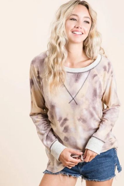 Model wearing a relaxed tie dye long sleeve top in soft neutral tones with contrast neckline and cuffs for a casual everyday look.