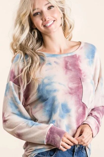 Pastel tie dye long sleeve top featuring soft blue and mauve tones with a relaxed neckline and casually layered style.