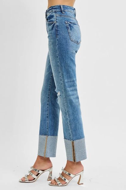 Side view of Risen high rise straight jeans featuring a wide cuffed hem and light distressing.